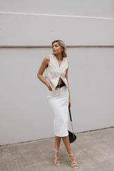 a lady in a white vest and a white skirt